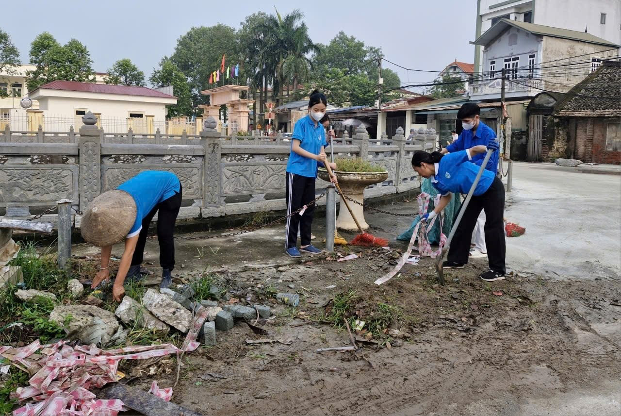 Hội Liên hiệp phụ nữ và Đoàn Thanh niên xã Đồng Quang, huyện Quốc Oai tích cực thu dọn bùn đất lắng đọng trên trục đường làng sau mưa bão. Ảnh: Hà Nội mới