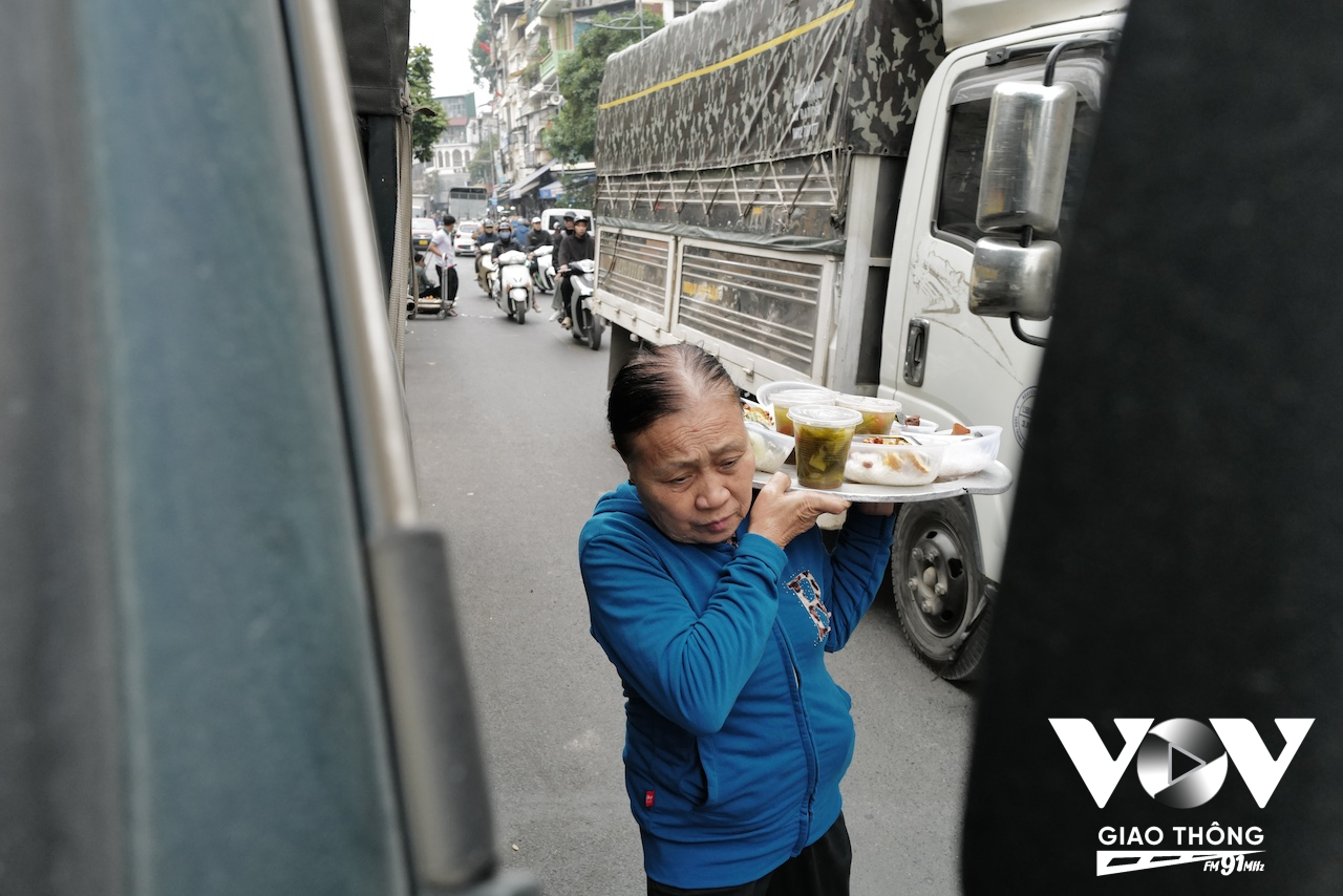 Một người phục vụ cơm trưa cho những người lao động tranh thủ ăn tại chỗ