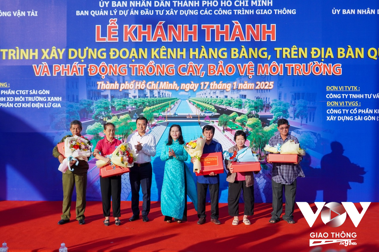 Bà Nguyễn Thị Lệ - Bí thư Thành ủy, Chủ tịch HĐND TPHCM cùng ông Bùi Xuân Cường - Phó chủ tịch UBND TP tặng hoa, cảm ơn những hộ dân đã tích cực trong việc giải phóng mặt bằng cho dự án