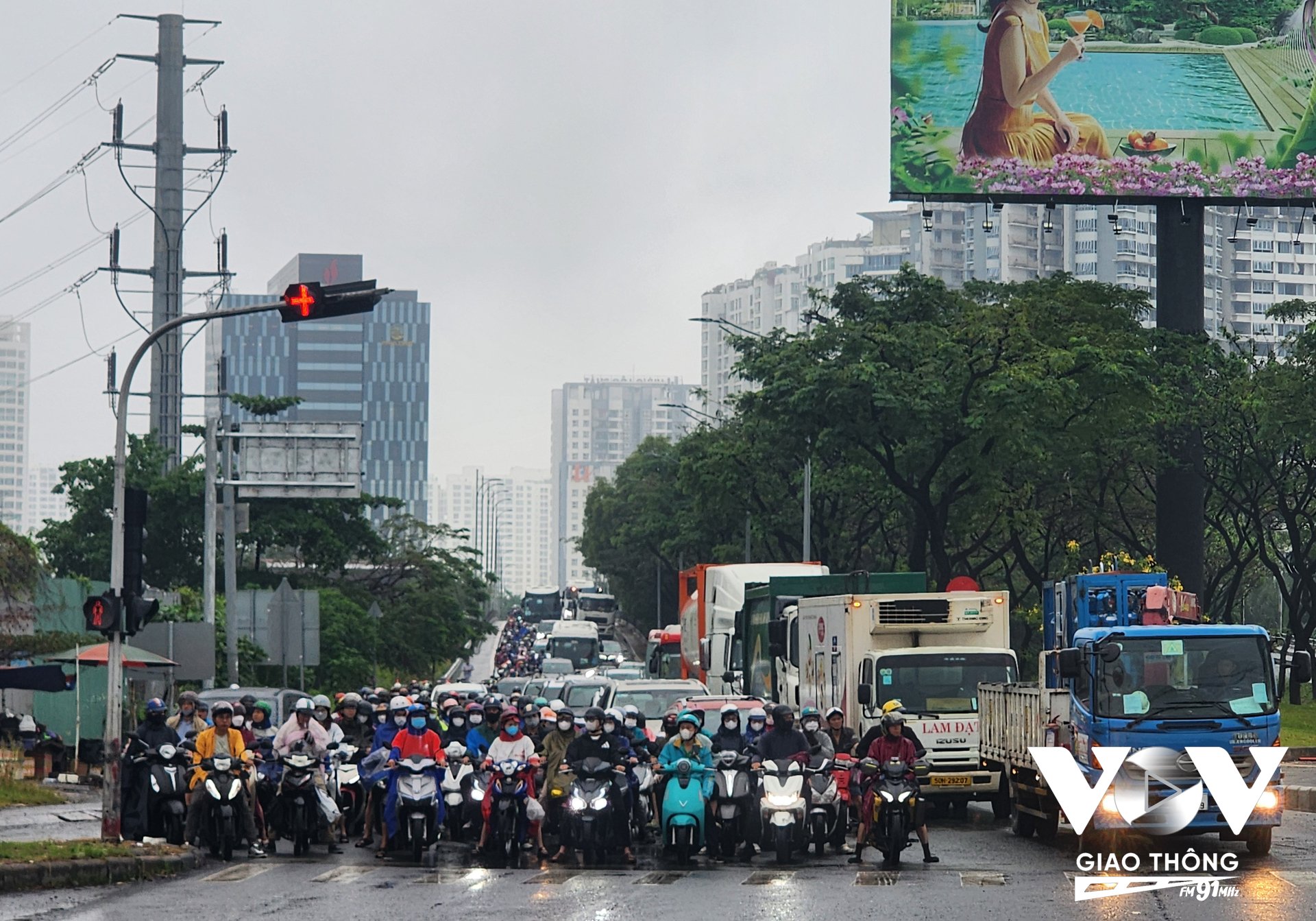 Ô tô, xe máy xếp hàng dài chờ lưu thông qua giao lộ Nguyễn Văn Linh - Nguyễn Hữu Thọ sau khi hầm chui đi vào hoạt động