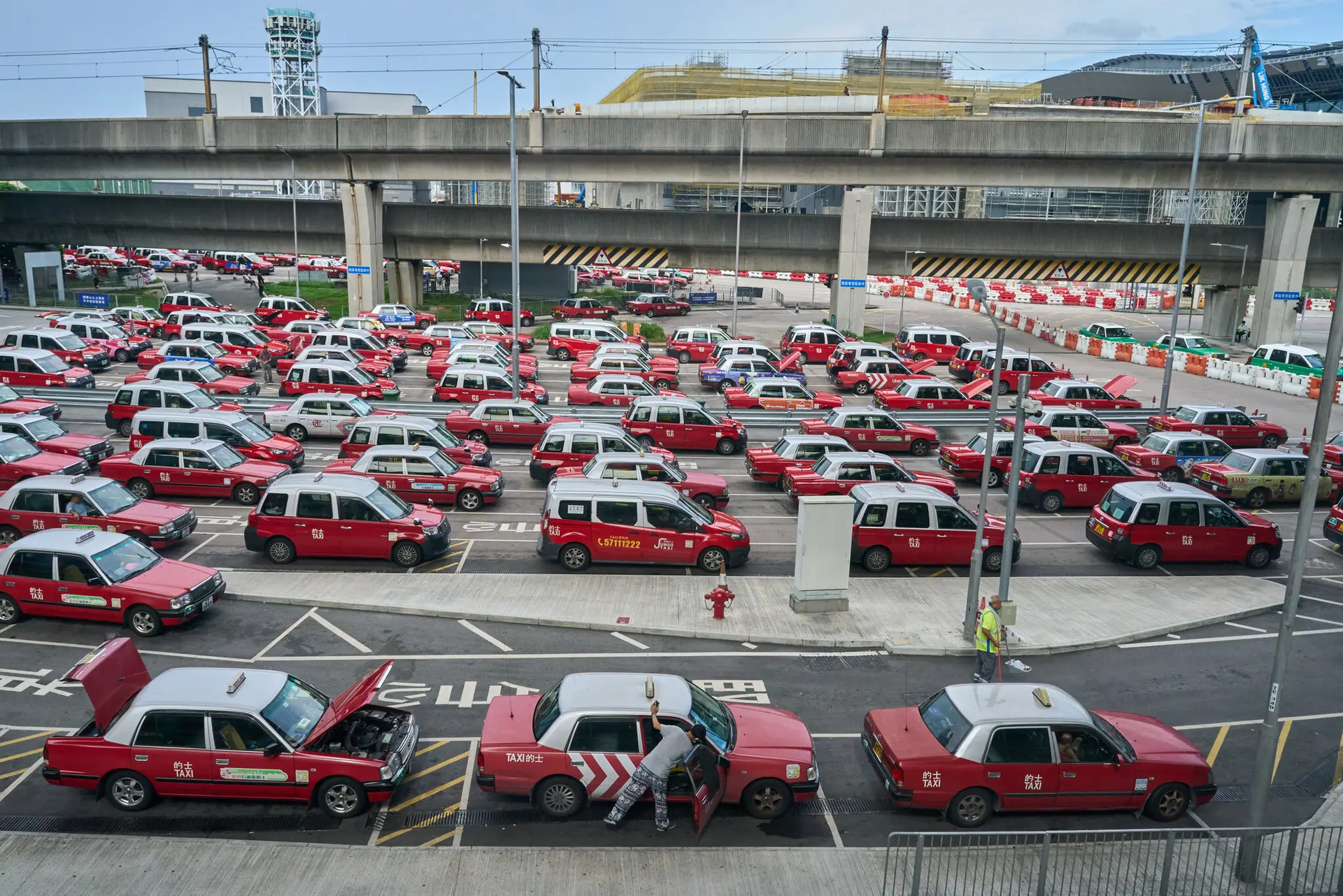 Một tài xế lau dọn taxi khi chờ tại sân bay vào tháng 8. Các quan chức đã triển khai một chiến dịch vào mùa hè nhằm kêu gọi các tài xế taxi cư xử lịch sự hơn. Ảnh: Anthony Kwan cho The New York Times