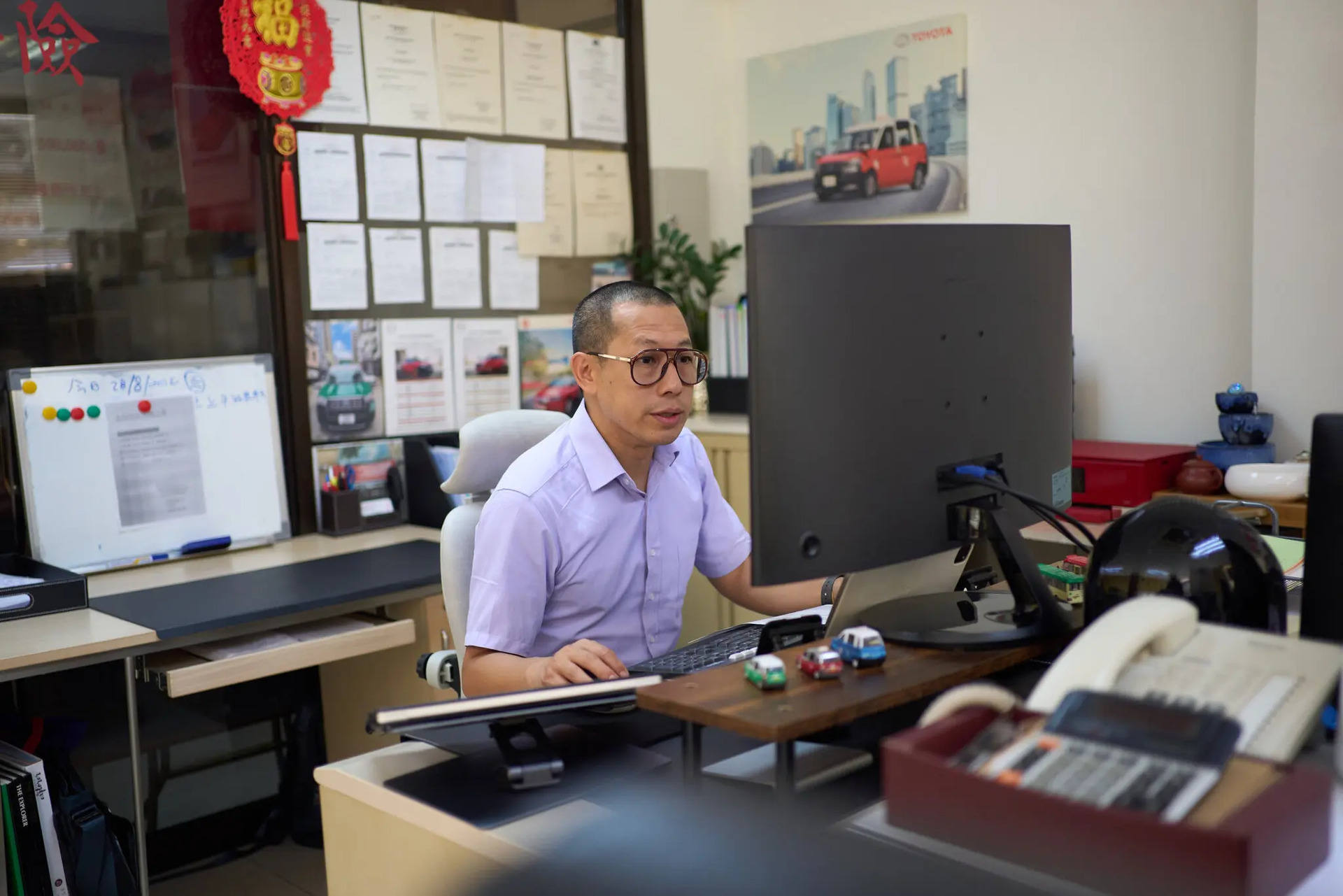Chris Chan, quản lý của Tin Shing Motors, tại văn phòng của ông ở Hong Kong. Ông cho biết biên lợi nhuận đã giảm sút, trong khi Uber ngày càng trở thành đối thủ cạnh tranh lớn. Ảnh: Anthony Kwan cho The New York Times