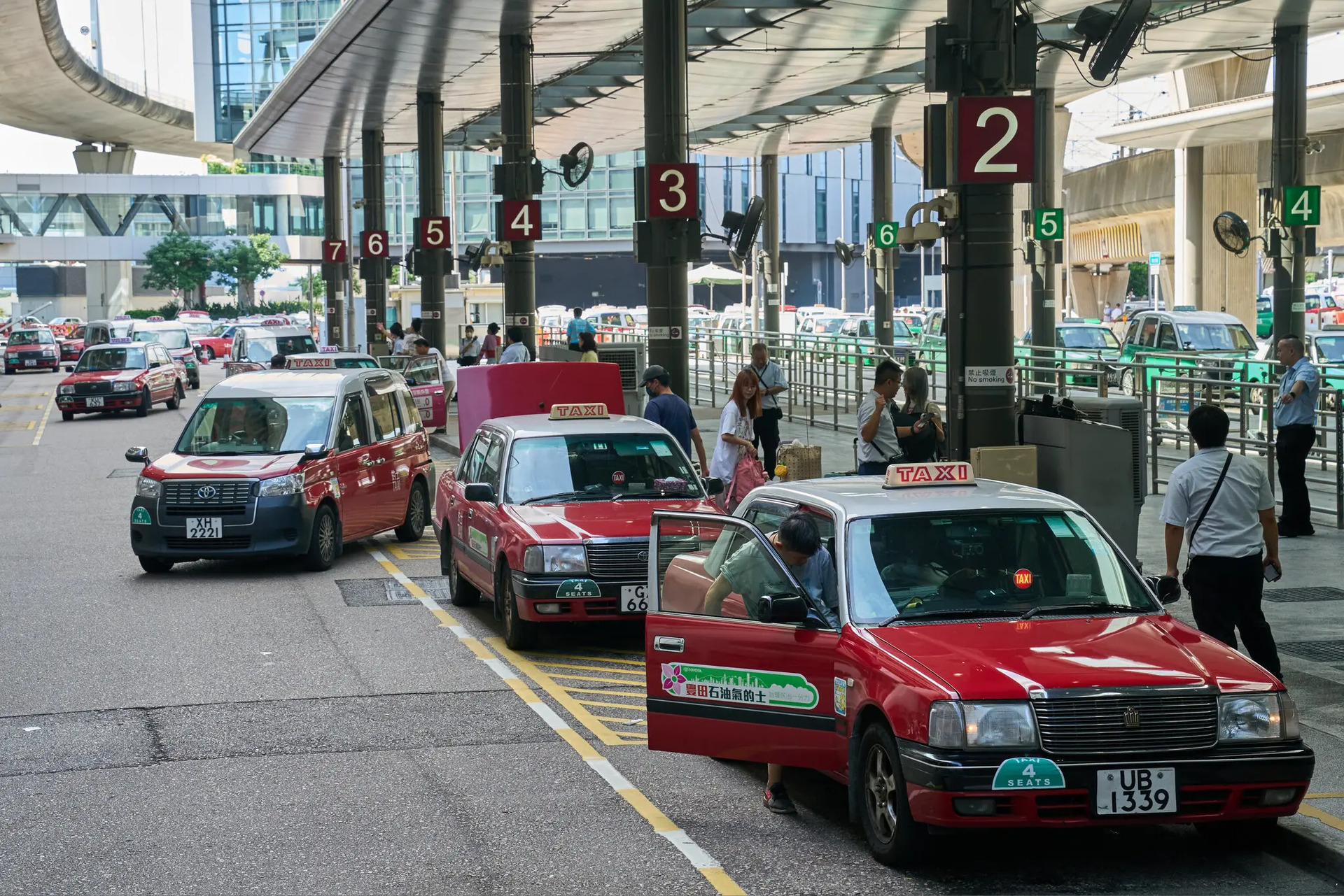 Các xe taxi đón khách tại Sân bay Quốc tế Hong Kong vào mùa hè năm ngoái. Nhân viên sân bay thường phải nhắc nhở du khách tại các điểm đón taxi rằng nhiều xe chỉ chấp nhận thanh toán bằng tiền mặt. Ảnh: Anthony Kwan cho The New York Times