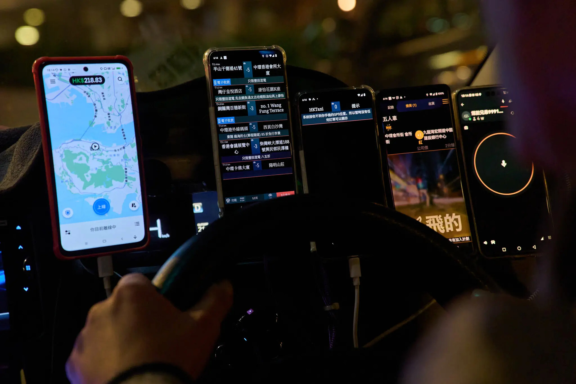 Các tài xế taxi thường gắn nhiều điện thoại di động trên bảng điều khiển để nhận cuộc gọi, sử dụng GPS và cập nhật thông tin về thị trường chứng khoán hoặc kết quả đua ngựa. Ảnh: Anthony Kwan cho The New York Times