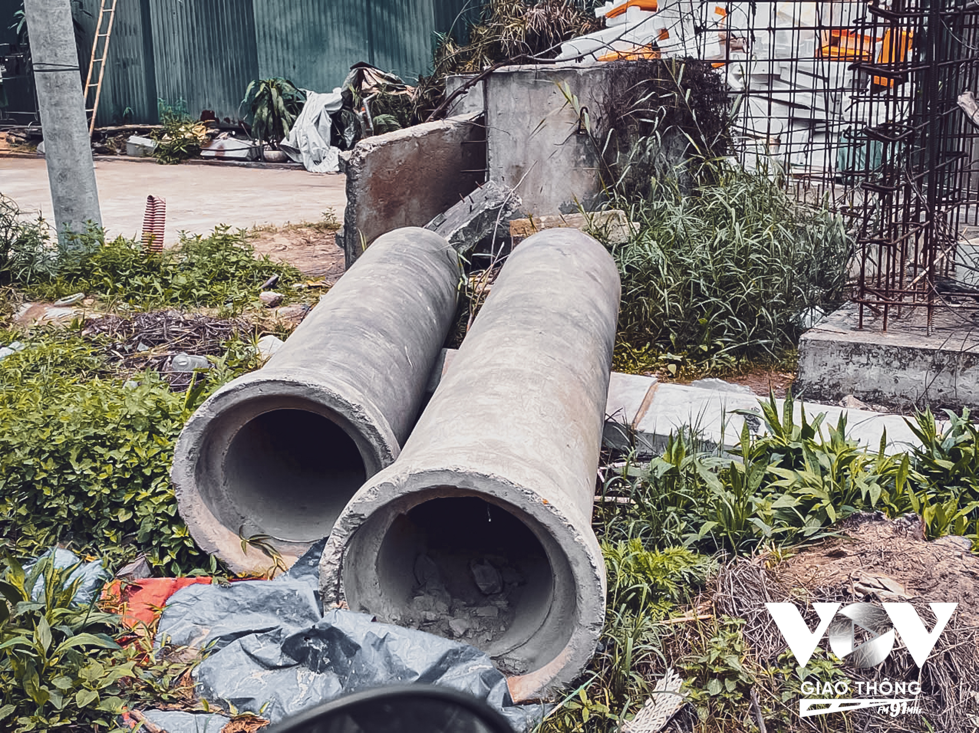 Bên cạnh đó, các vật liệu xây dựng như bê tông, sỏi cát chất đống hai bên đường gây ảnh hưởng không nhỏ đến người tham gia giao thông