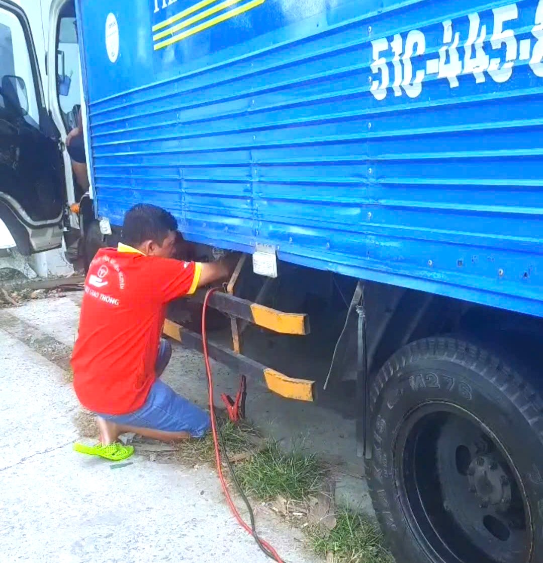 Anh Tùng kích bình cho xe bị sự cố trên đường. (Ảnh: Nhân vật cung cấp)