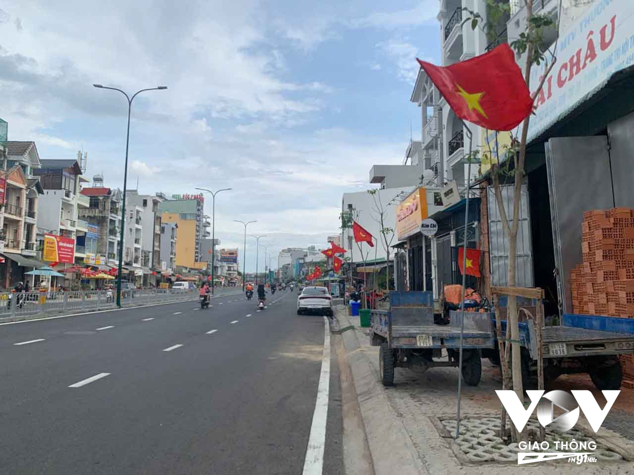 Đoạn đường đã hoàn thành các hạng mục thảm nhựa, lắp lan can, sơn vạch kẽ đường, được người dân trang trí treo cờ chào mừng 30/4