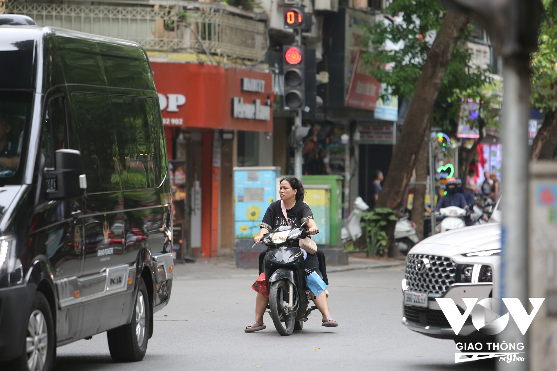 Kẹp 3, không đội mũ bảo hiểm, vượt đèn đỏ - người phụ nữ này điều khiển xe máy trên phố Hàng Bông vi phạm tới 3 lỗi... Tình trạng không đội mũ bảo hiểm khi ngồi trên xe máy khá phổ biến ở khu vực phố cổ, nơi thường ít có bóng dáng lực lượng chức năng kiểm tra