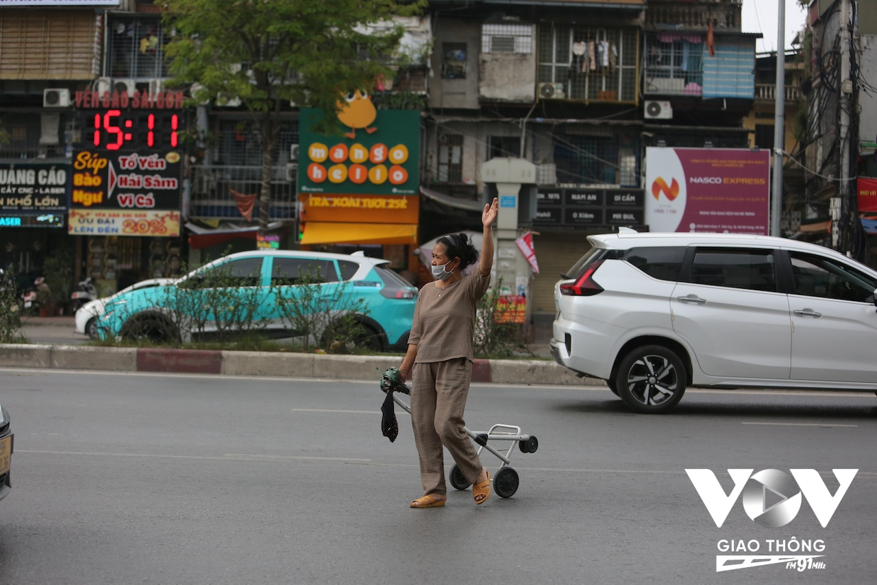Một người đi bộ vô tư kéo xe đi cắt qua đoạn dốc cuối đường vành đai 2 trước cổng khu đô thị Times City
