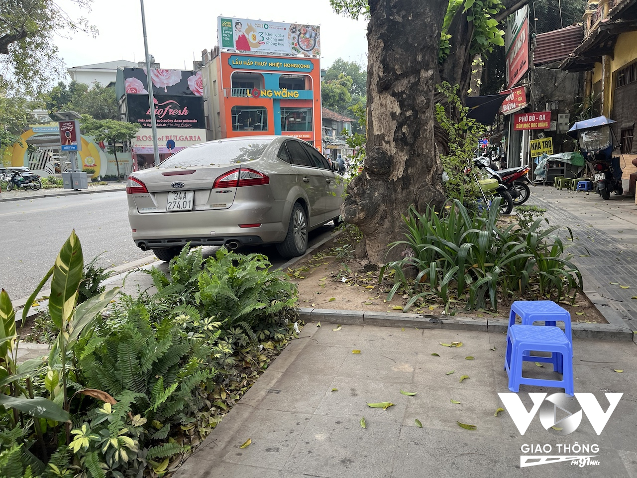 Một chiếc xe đỗ trên vỉa hè cạnh ngã tư Hai Bà Trưng - Quán Sứ, phía đối diện là chốt cảnh sát giao thông