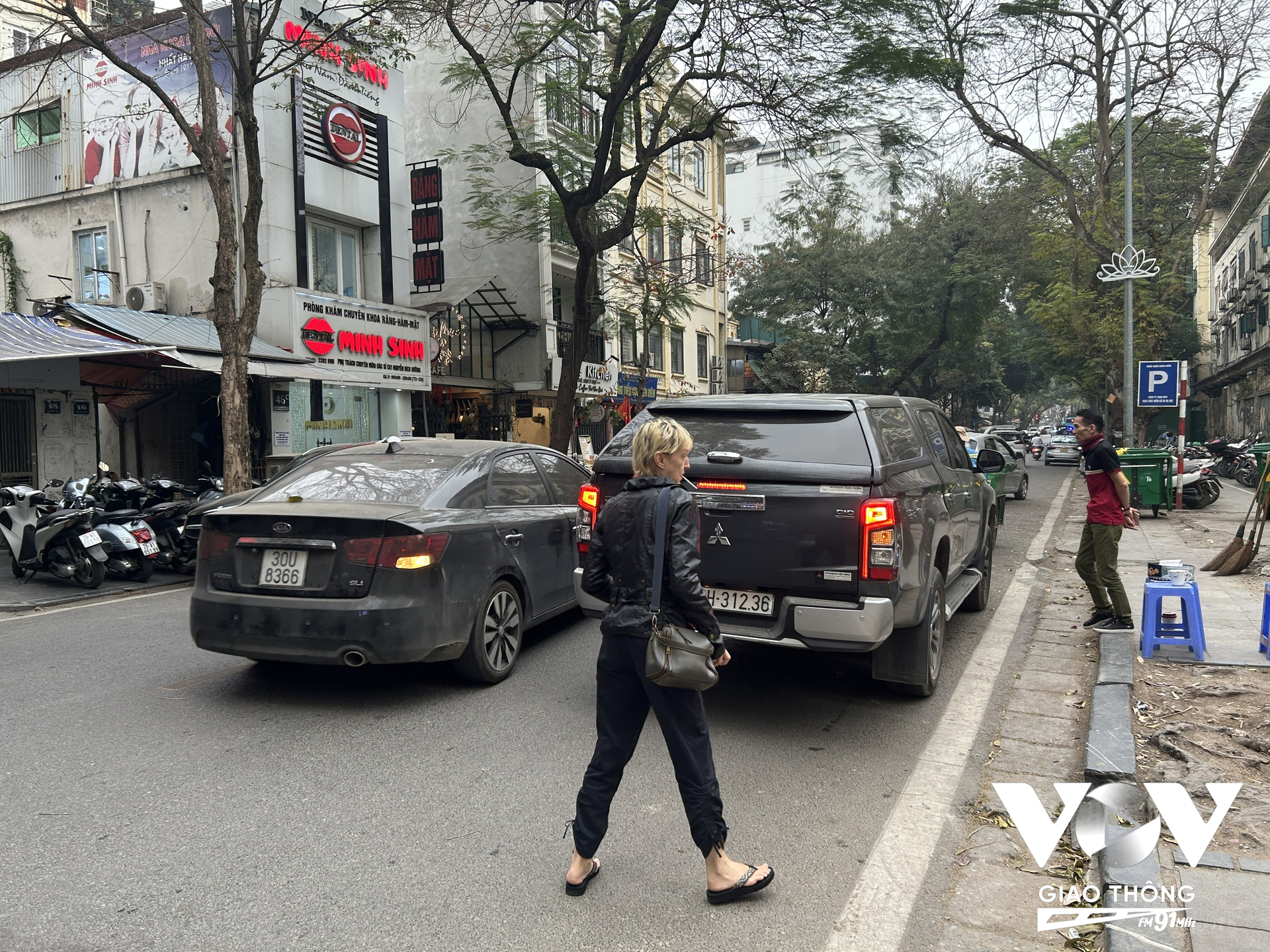 Một du khách nước ngoài lúng túng không biết phải đi kiểu gì khi nhiều đoạn vỉa hè và lòng đường đã chật kín ô tô dừng đỗ