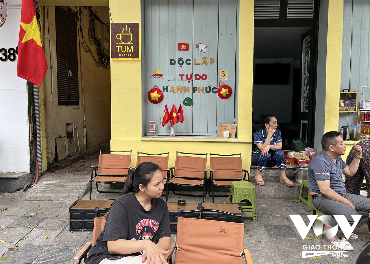 Một quán trà đá trên phố cổ Hà Nội trang trí cờ hoa và dòng chữ tự hào: Độc lập - Tự do - Hạnh phúc