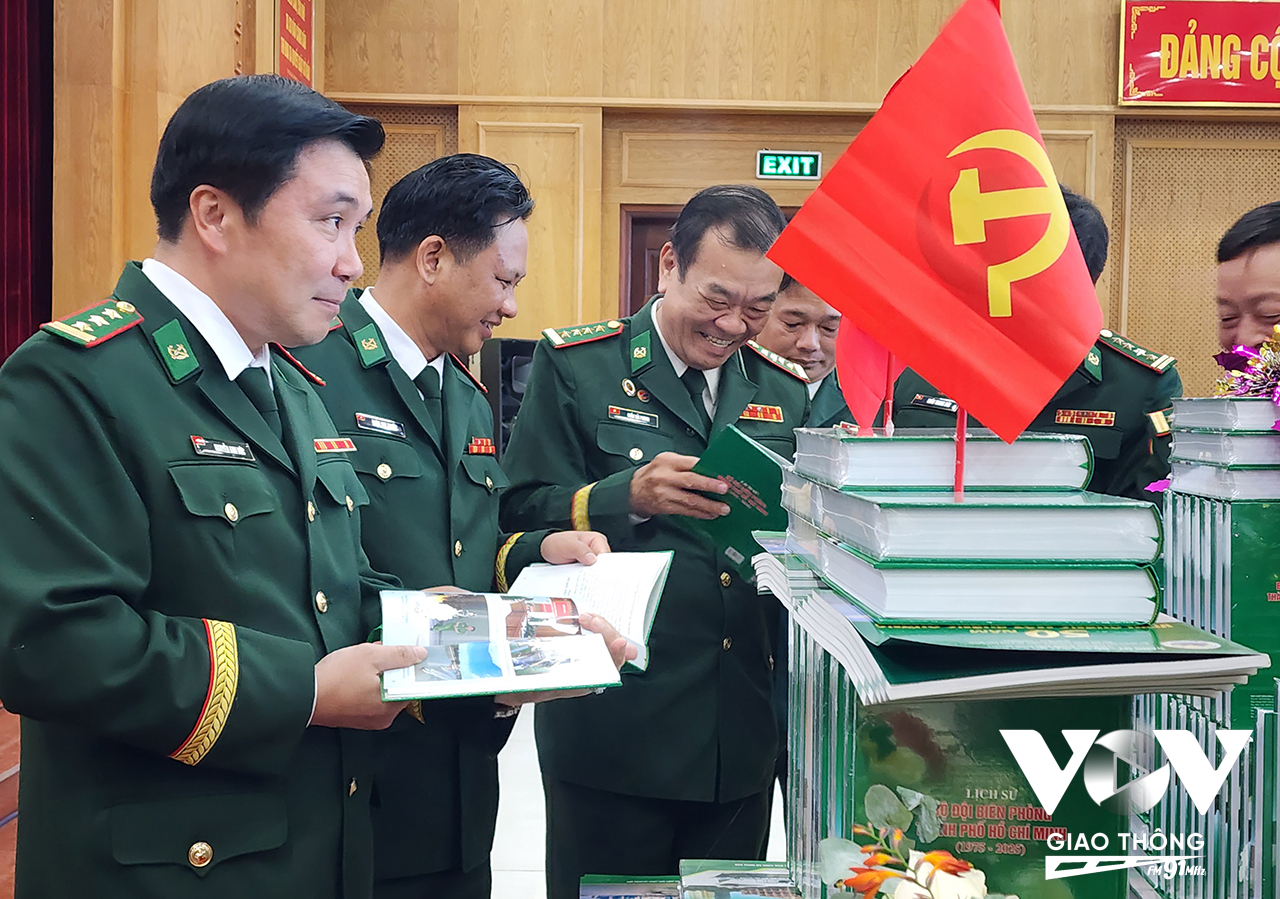 Các đại biểu, khách mời xem cuốn sách lịch sử Bộ đội Biên phòng TP. Hồ Chí Minh tại buổi lễ