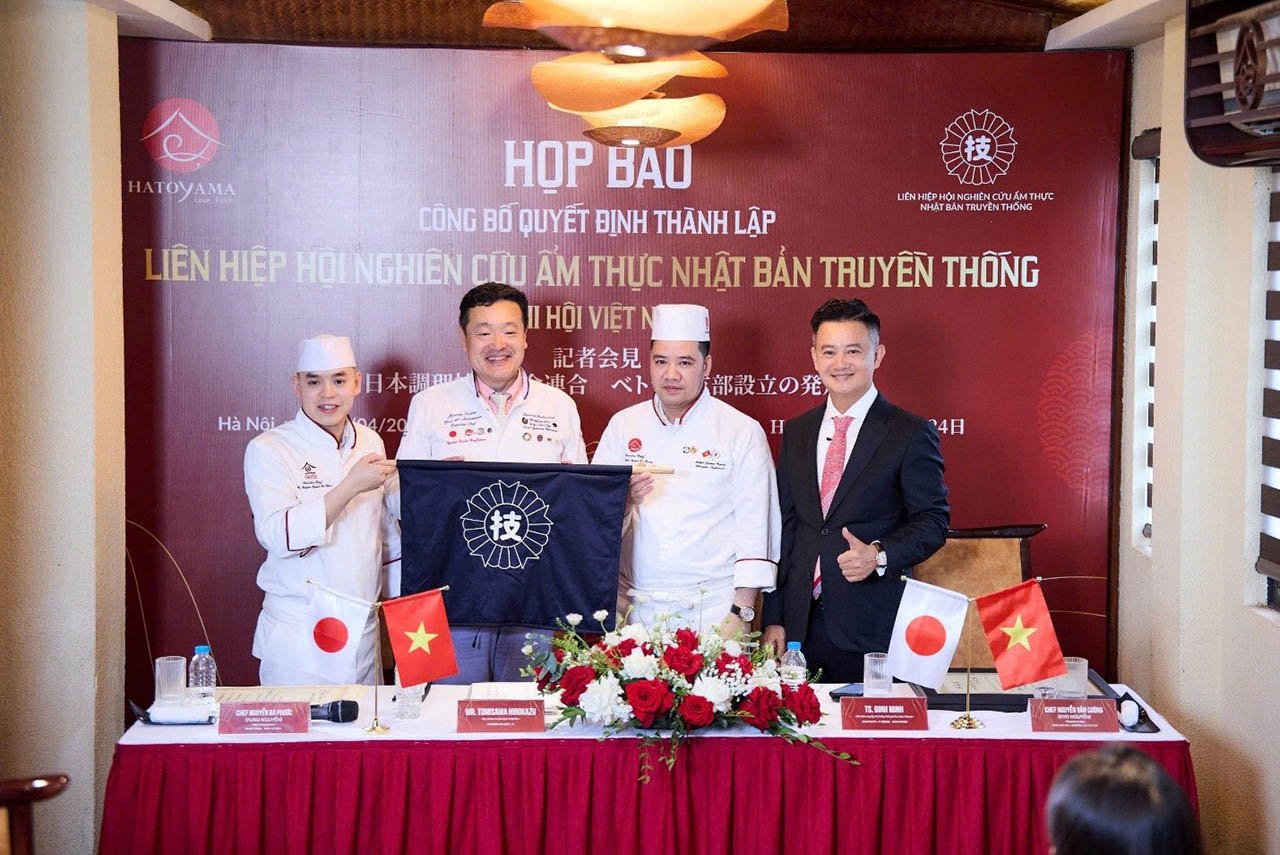 Ông Tomisawa trao lá cờ biểu tượng của Liên hiệp hội Nghiên cứu ẩm thực Nhật Bản truyền thống cho đại diện Chi hội Việt Nam.