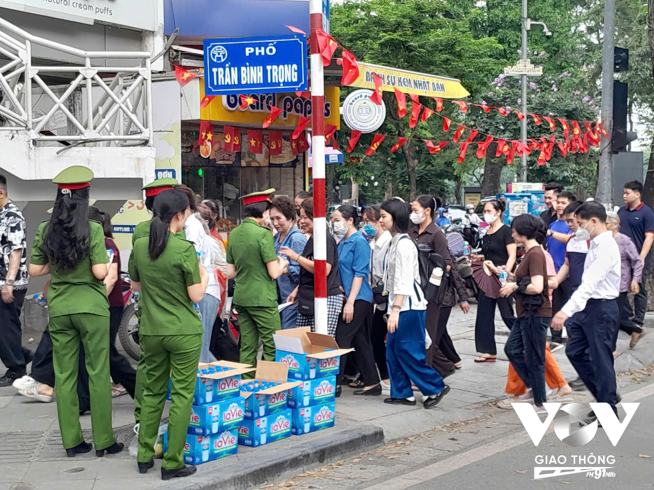 Lực lượng chức năng phát nước hỗ trợ người dân trong tiết trời nắng nóng.