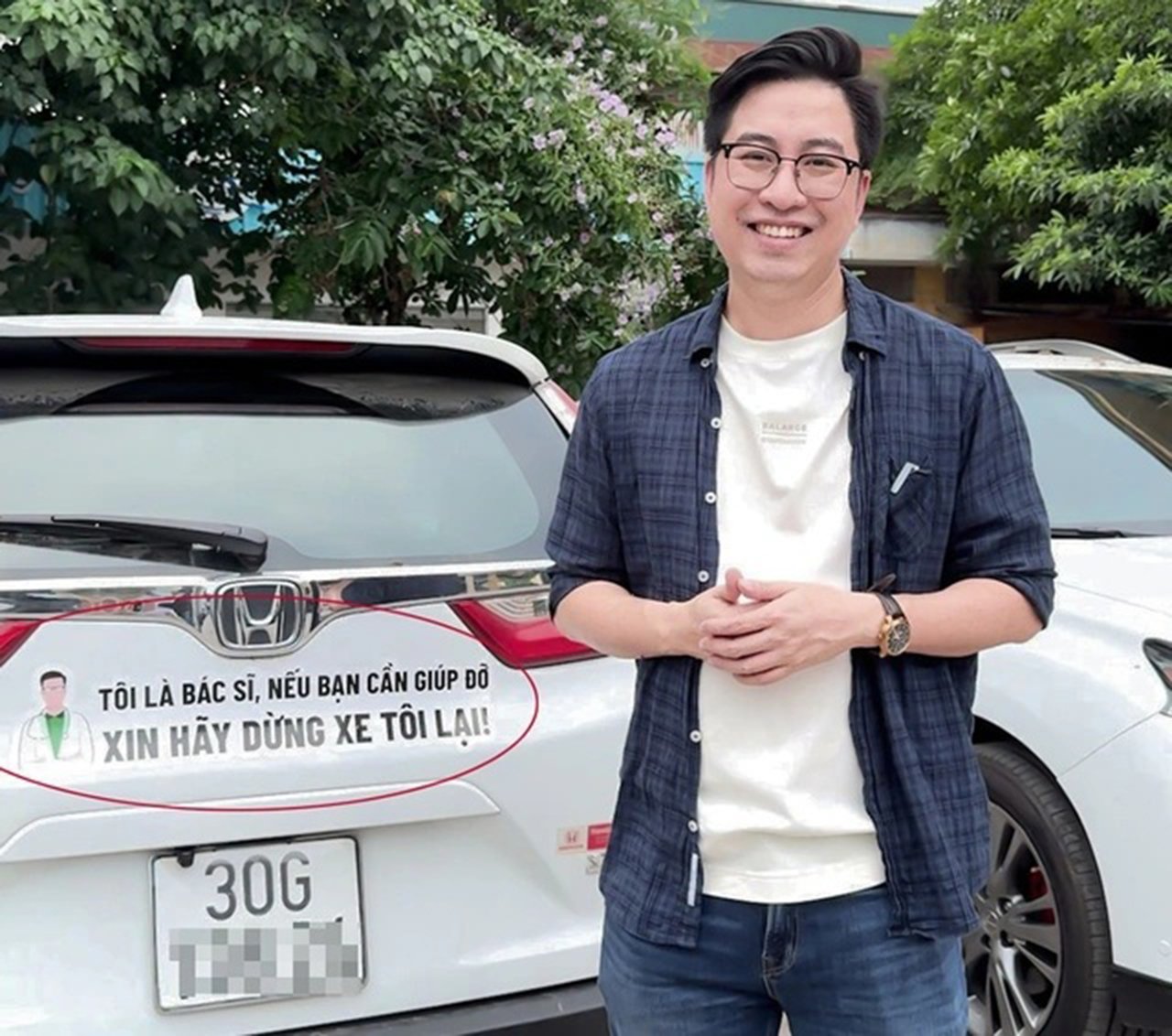 Bác sĩ Phạm Tiến Mạnh và dòng chữ sau xe 'Tôi là bác sĩ. Nếu bạn cần giúp đỡ, xin hãy dừng xe tôi lại'. (Ảnh NVCC)
