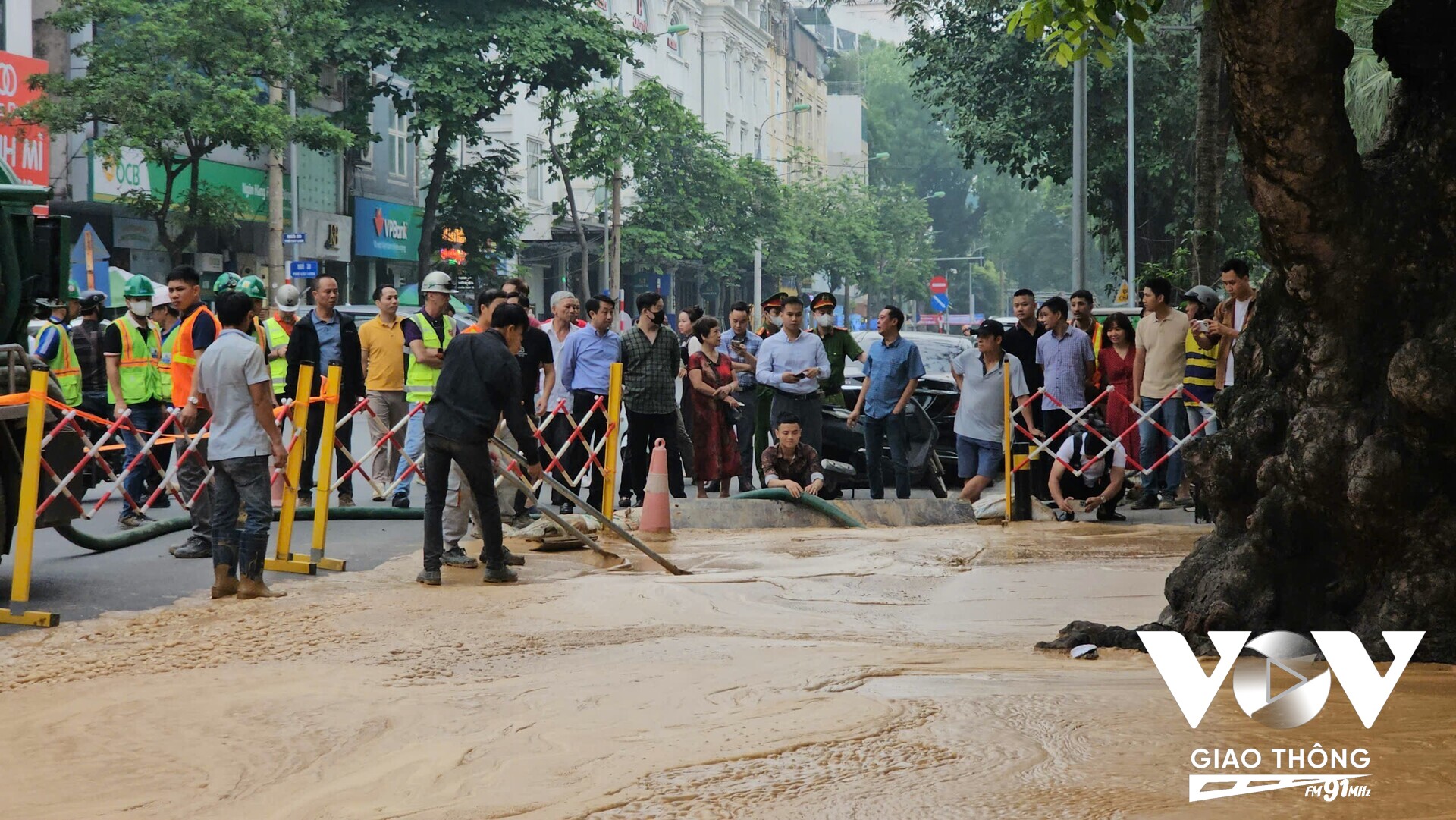 Công nhân và máy hút chuyên dụng đang thu dọn phụ gia phun trào