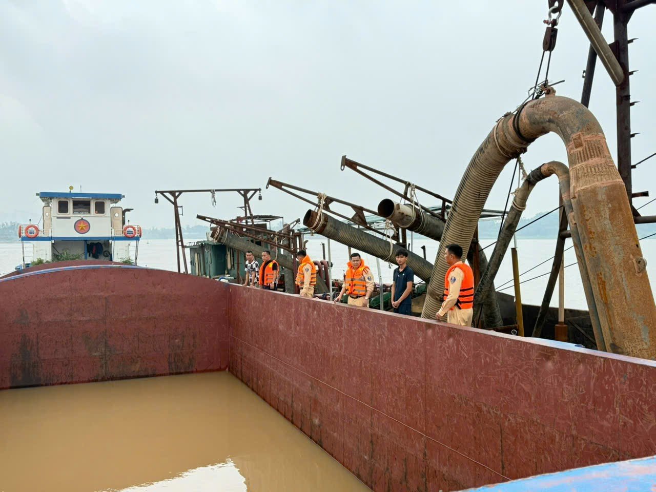 Các đối tượng bị bắt giữ khi mới khai thác được khoảng 10m³ cát lẫn nước (Nguồn: Phòng CSGT, Công an TP. Hà Nội)