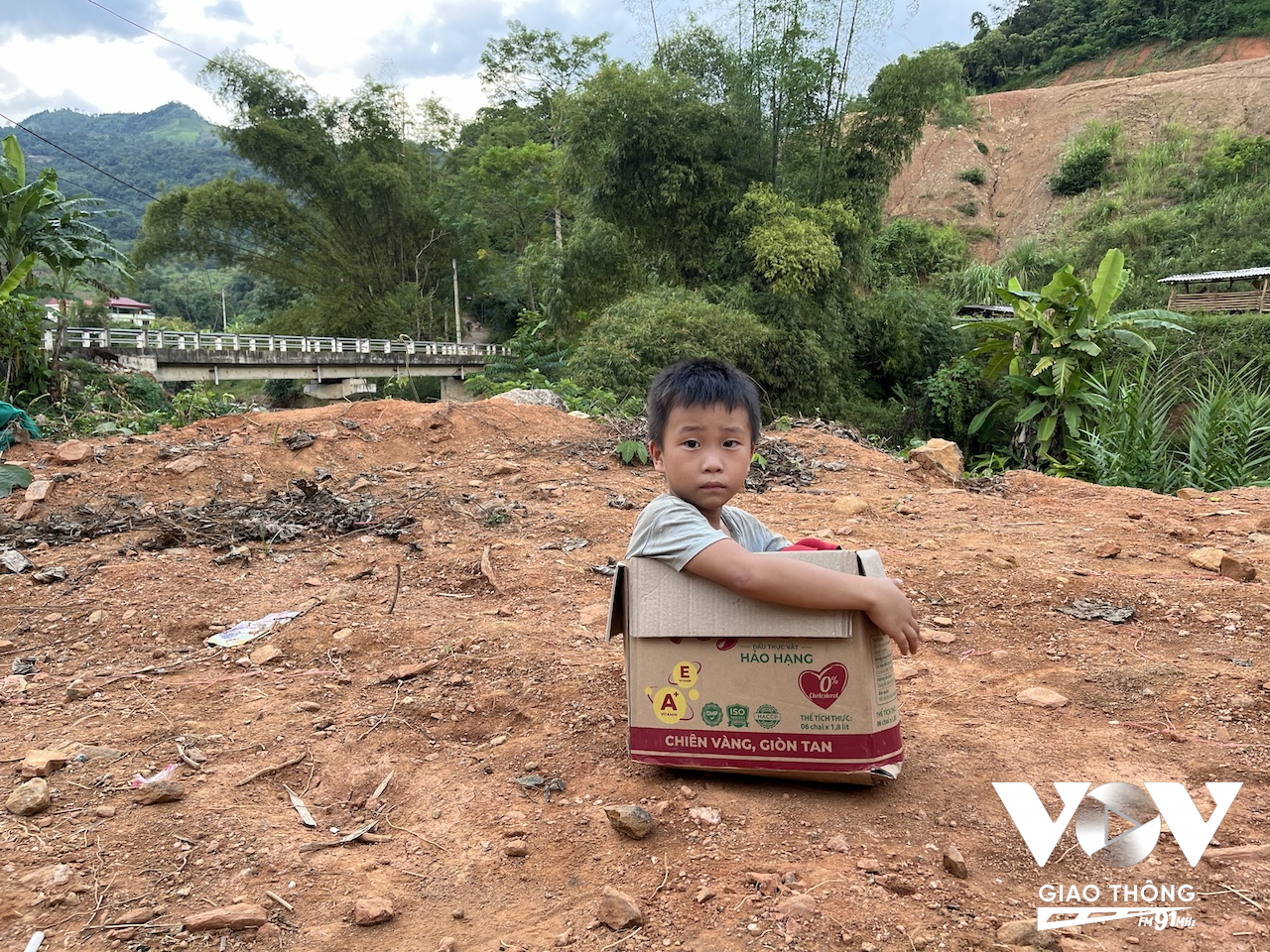 Cậu bé ngồi chơi trong một chiếc hộp carton đựng đồ cứu trợ của những người làm thiện nguyện khắp nơi mang về giúp đỡ người dân chịu cảnh thiệt hại trong trận lũ lụt lịch sử tháng 9/2024. (Ảnh chụp tại thôn Nà Mơ, Cao Bằng)
