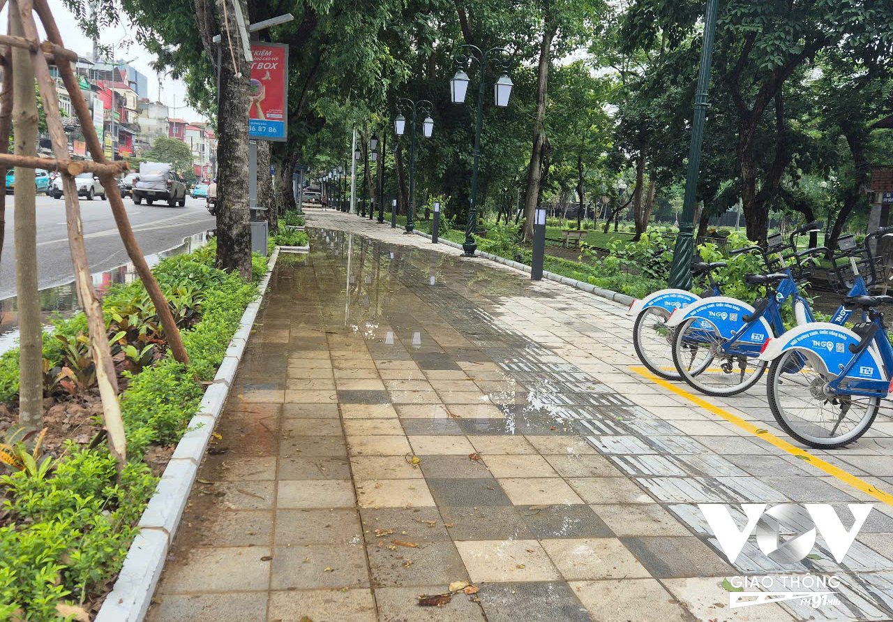 Dù mưa không lớn, trôi qua khá lâu, song nước vẫn đọng trên vỉa hè trước cổng công viên Thống Nhất trên đường Lê Duẩn