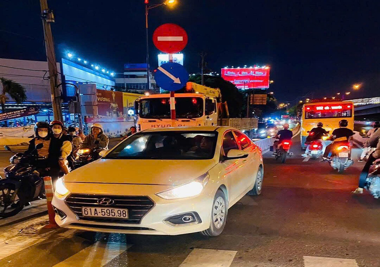 Xe ô tô màu trắng mang BKS 61A – 595.98, lưu thông ngược chiều trên đường song hành Võ Nguyên Giáp đoạn gần ngã 4 Thủ Đức