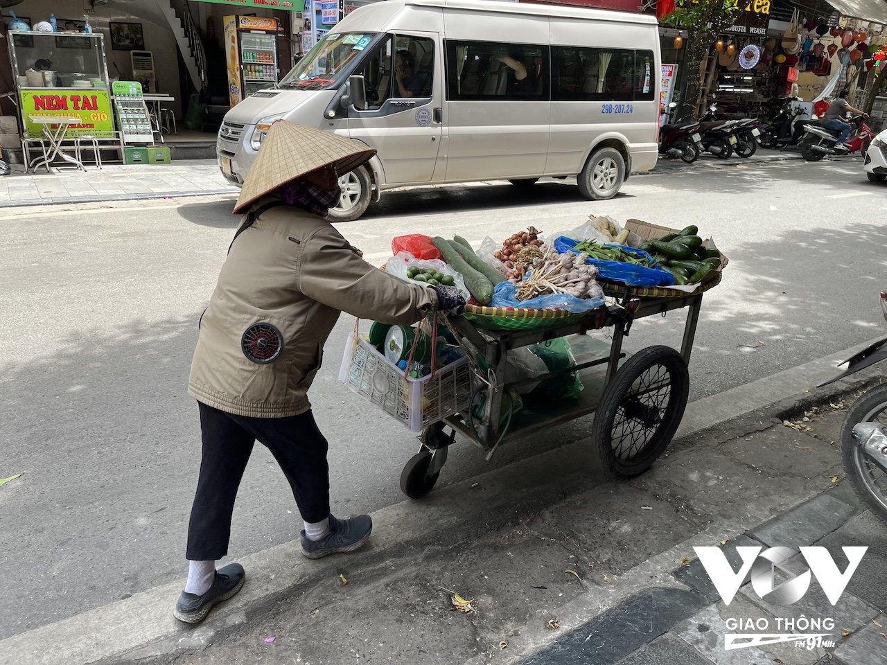 Một người bán hàng rong trang bị chiếc áo khoác có gắn quạt mát giảm nhiệt khi phải lao động ngoài trời cả ngày