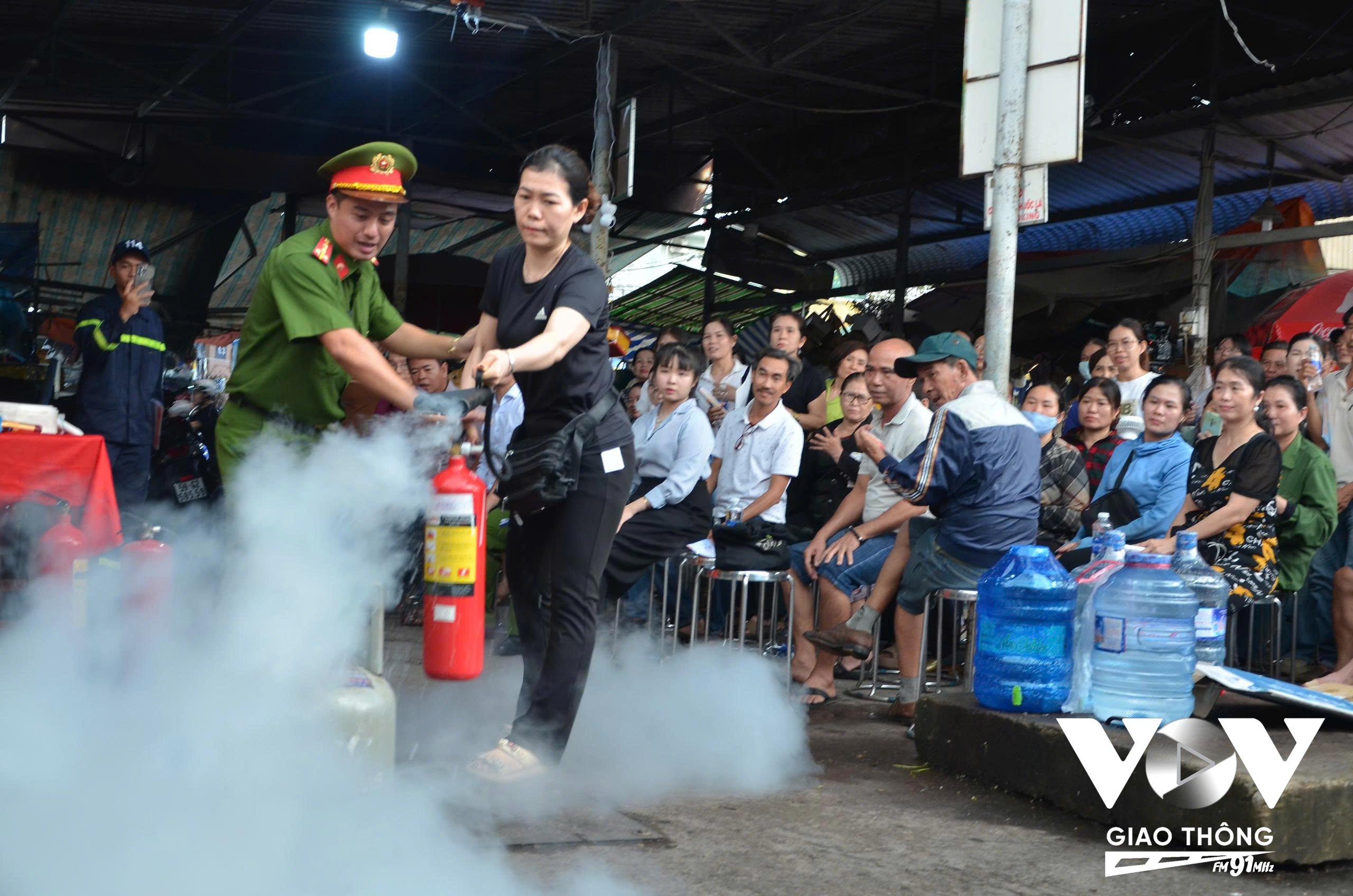 Lực lượng Cảnh sát PCCC và CNCH hướng dẫn các tiểu thương cách sử dụng bình cứu hỏa.