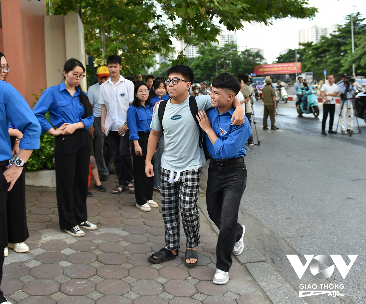 Một trường hợp thí sinh bị đau chân được sinh viên tình nguyện giúp đưa vào phòng thi