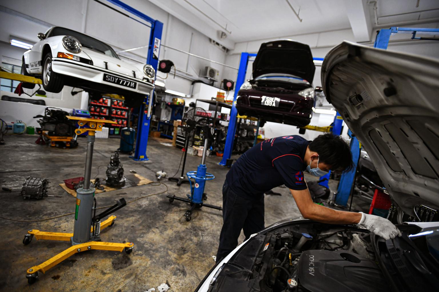 Thợ sửa chữa làm việc tại một garage ô tô ở Singapore. Ảnh: Lim Yaohui/The Strait Times