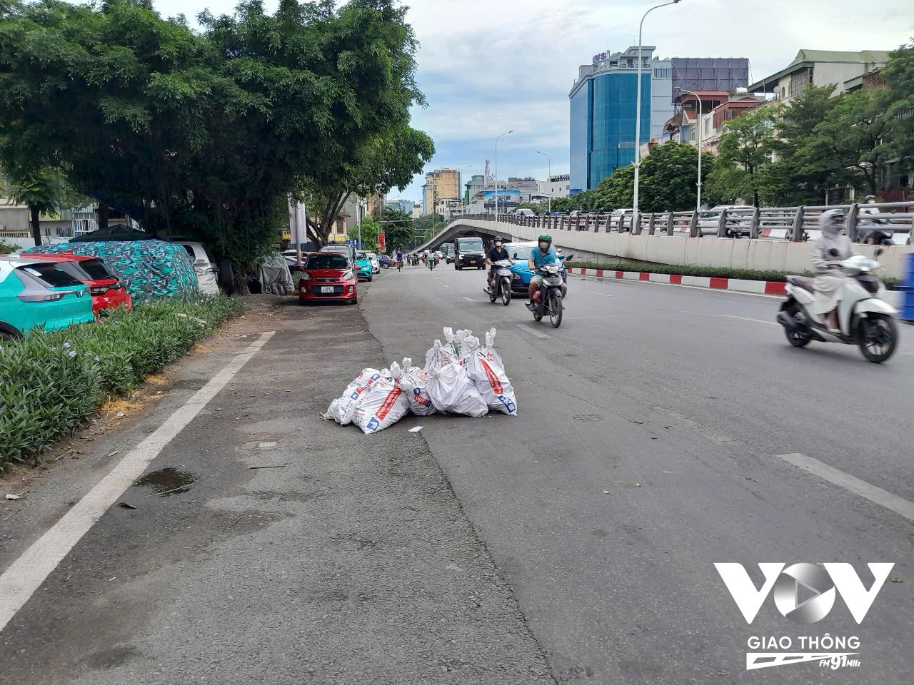 Hàng chục bao tải đựng phế thải xây dựng nằm ngổn ngang chiếm gần hết một làn đường phố Trần Khát Chân