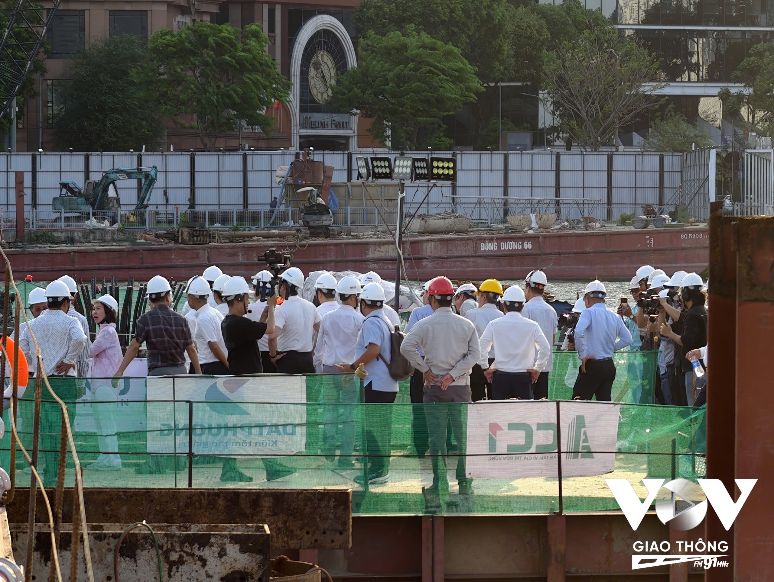 Đại diện các sở ngành, đơn vị thi công và báo chí theo dõi quá trình triển khai mẻ đổ bê tông đầu tiên tại công trường cầu đi bộ qua sông Sài Gòn.