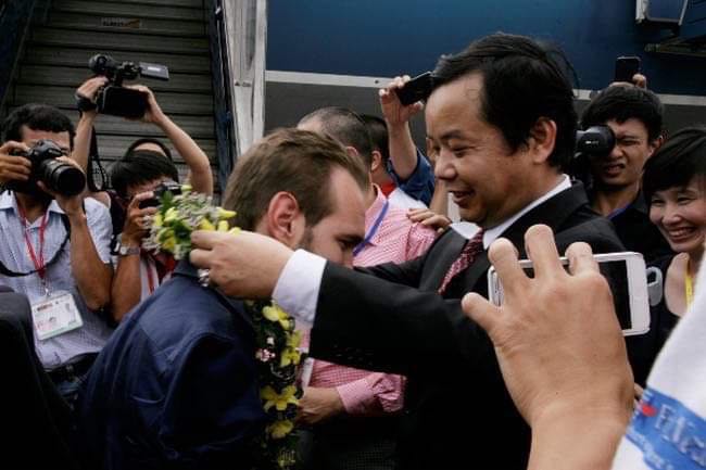 Ông Phước trao vòng hoa cho Nick Vujicic ngay khi vừa xuống máy bay diễn thuyết ở SVĐ Việt Nam.