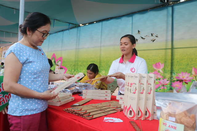 Bạn Ngô Ngọc Anh (bìa phải), giới thiệu sản phẩm nhang sen sạch Liên Tâm tại Phiên chợ Nông nghiệp xanh năm 2018