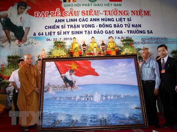 Ông  Phước (bìa phải) trong đêm đấu giá chính thức bức tranh lịch sử ‘Gạc Ma - Vòng Tròn Bất Tử’ giúp đỡ 64 gia đình liệt sĩ hy sinh ở Gạc Ma tại chùa Vĩnh Nghiêm 22/7/2015.