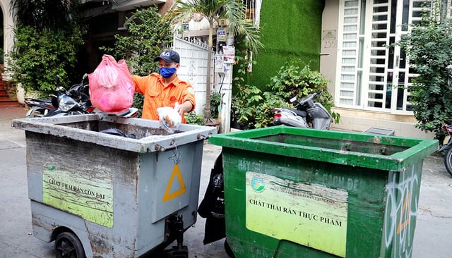 Công nhân thu gom rác phân loại tại hẻm 25 Nguyễn Bỉnh Khiêm, Q.1, TP.HCM - Ảnh: NGỌC PHƯỢNG