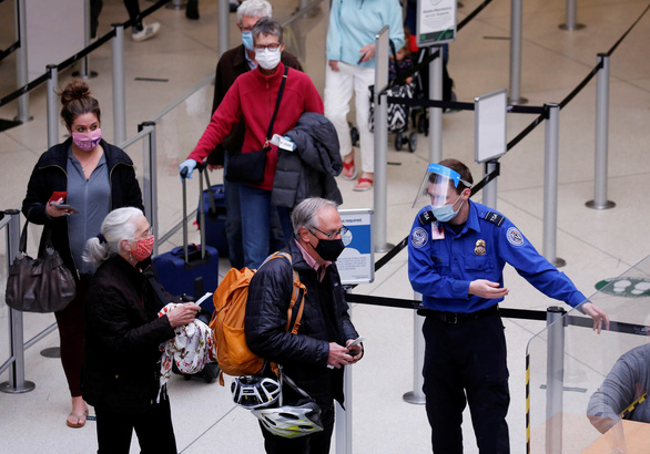 Hành khách xếp hàng làm thủ tục an ninh và kiểm dịch tại một sân bay ở Mỹ tháng 4-2021 - Ảnh: REUTERS