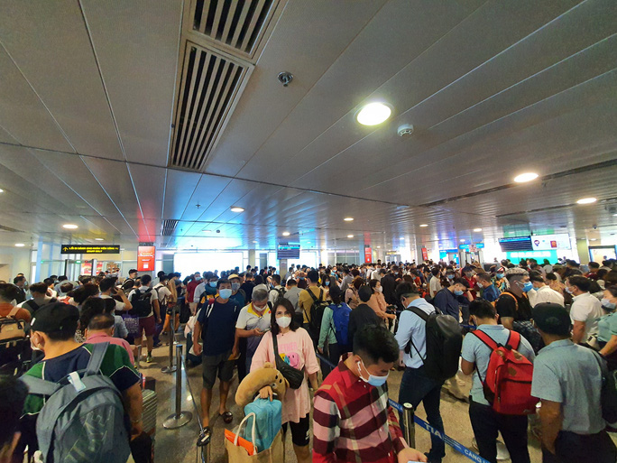 Hàng ngàn hành khách phải xếp hàng cả tiếng đồng hồ chờ làm thủ tục soi chiếu an ninh ở sân bay Tân Sơn Nhất - Ảnh: Lam Giang
