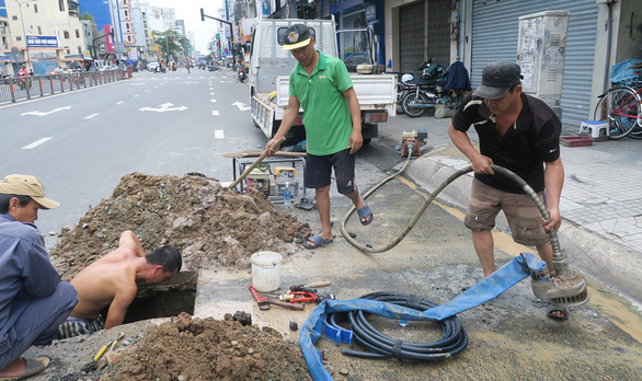 Công nhân Công ty cổ phần Cấp thoát nước Gia Định sửa chữa ống nước trên đường Hoàng Văn Thụ, P.9, Q.Phú Nhuận - Ảnh: NGUYỆT NHI