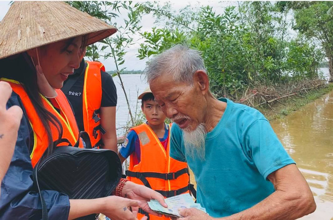 Ca sĩ Thủy Tiên trao tiền từ thiện cho người dân miền Trung. (Ảnh từ Facebook của ca sĩ)