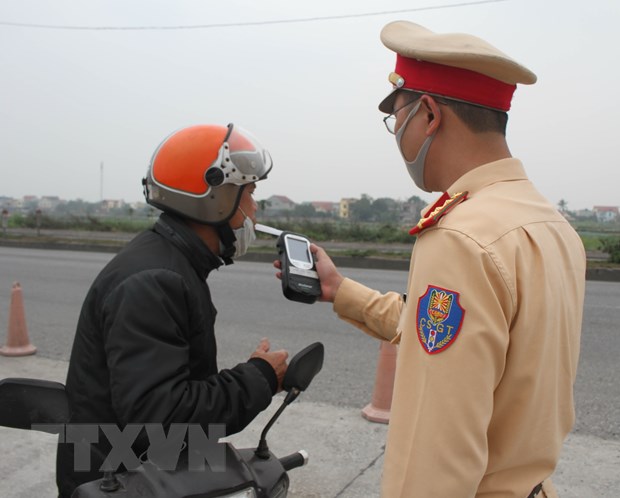 Cảnh sát giao thông kiểm tra nồng độ cồn của người điều khiển phương tiện. (Ảnh: Thùy Dung/TTXVN)