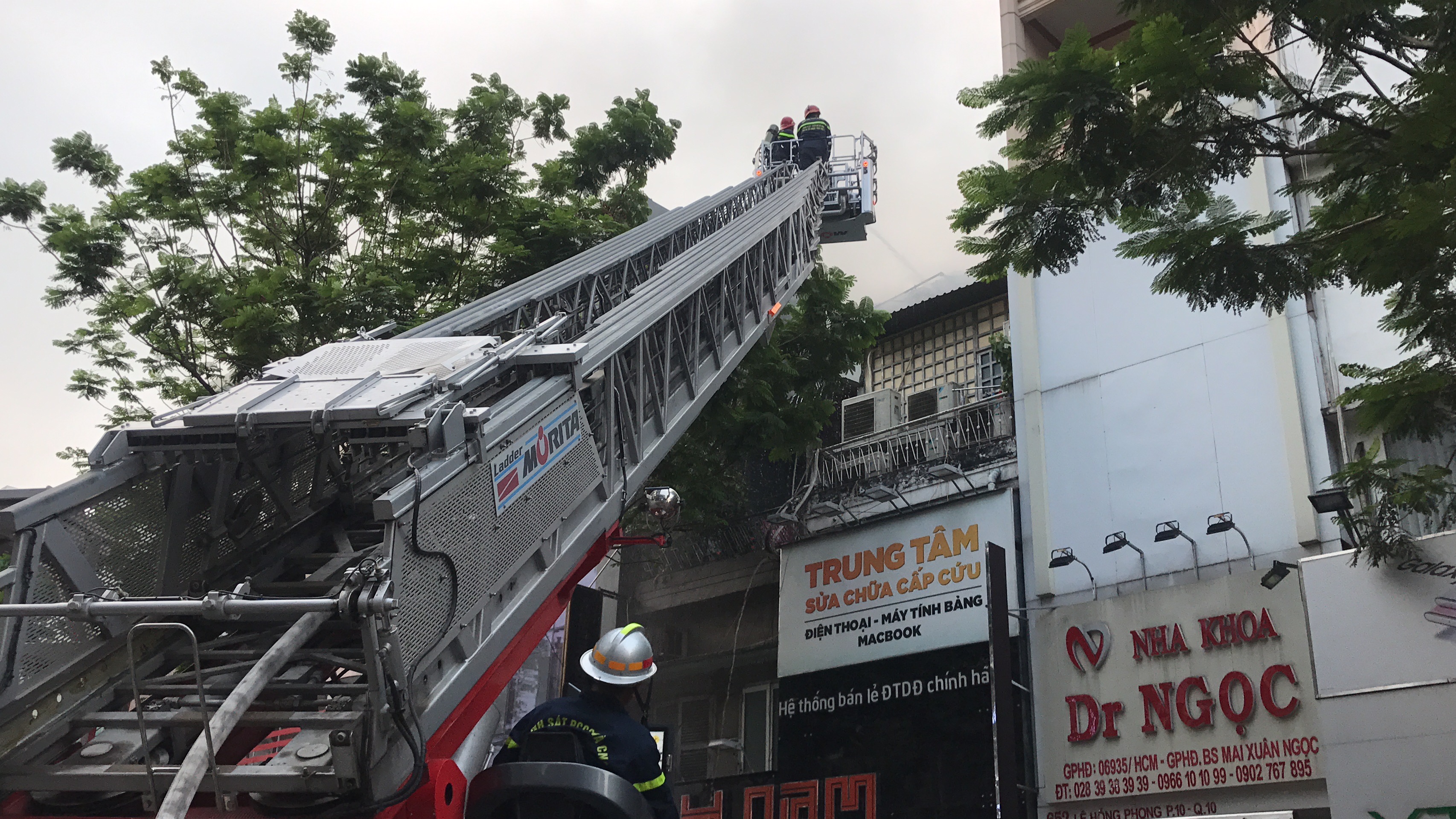 Lực lượng PCCC dùng xe thang phun nước khống chế ngọn lửa