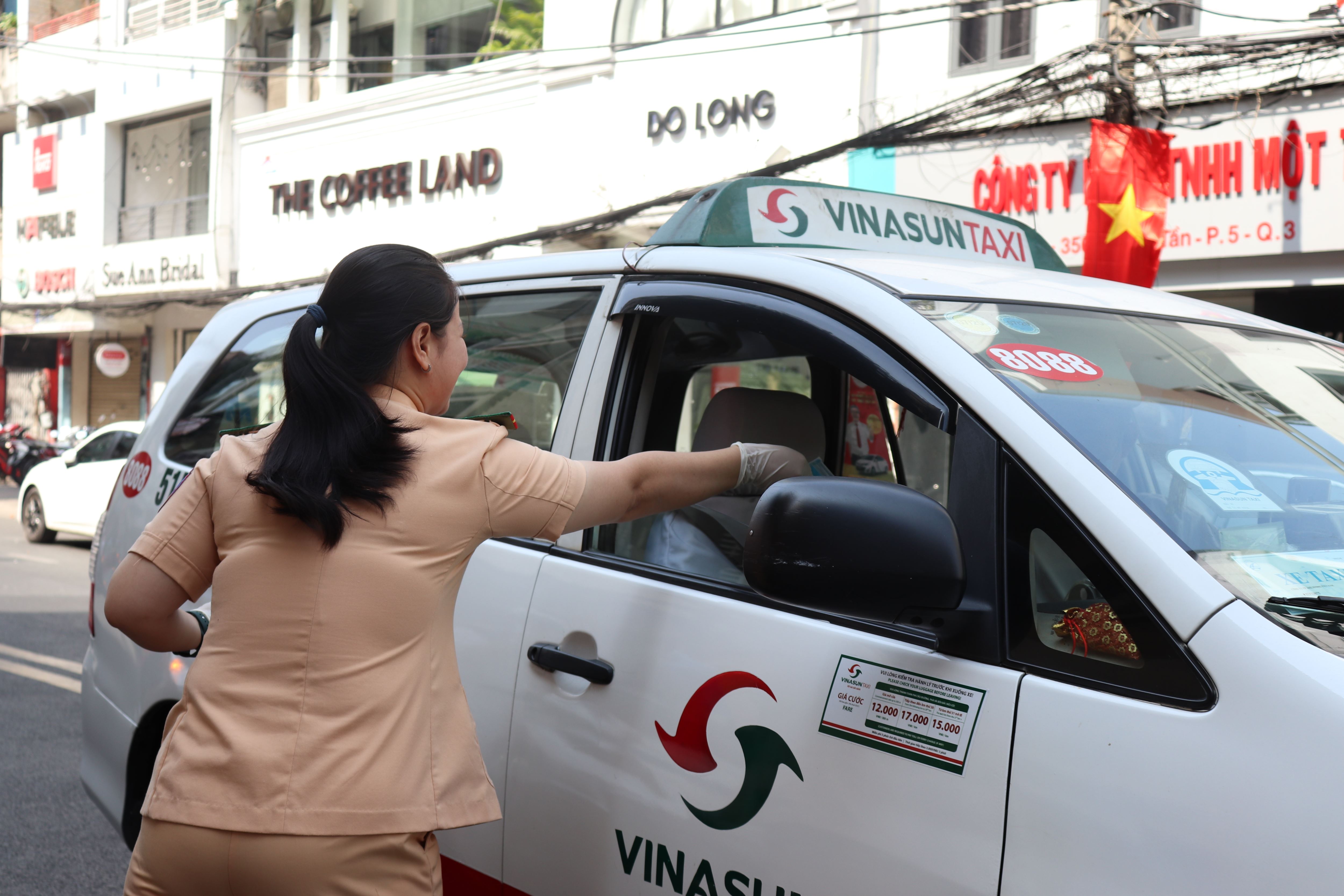 Nhiều tài xế xe taxi cũng tranh thủ nhận khẩu trang khi đi qua điểm phát trên đường Võ Văn Tần