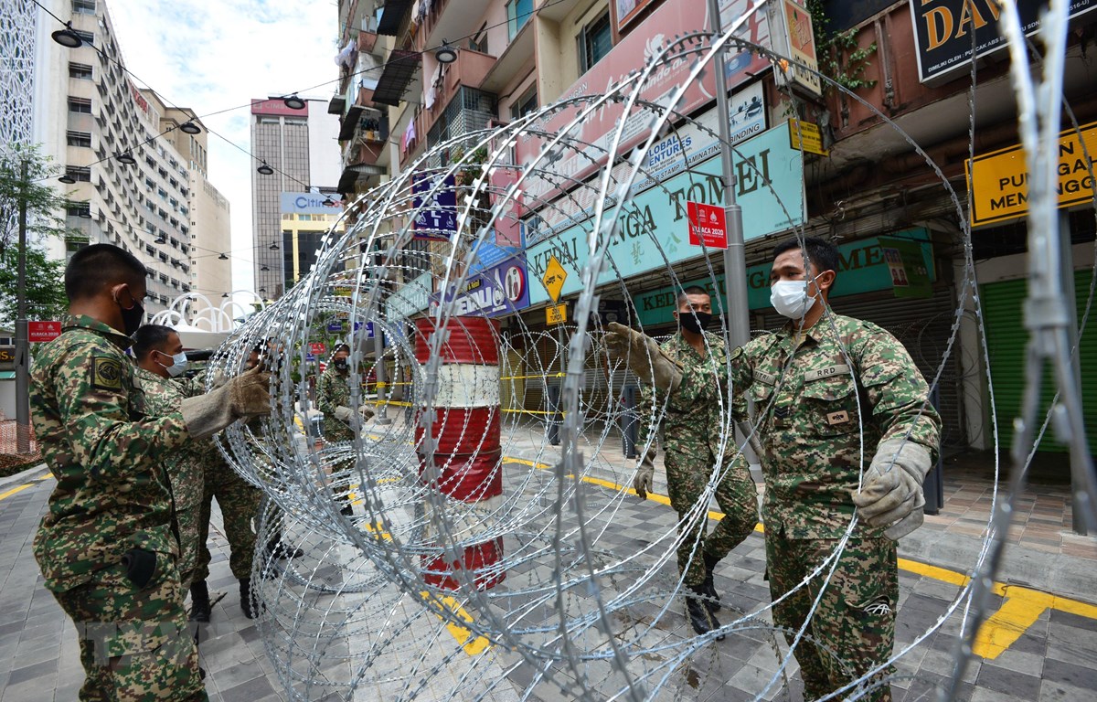 Binh sỹ Malaysia đặt rào chắn để thực hiện Mệnh lệnh Kiểm soát Di chuyển (MCO) tại Kuala Lumpur, Malaysia (Ảnh: TTXVN)