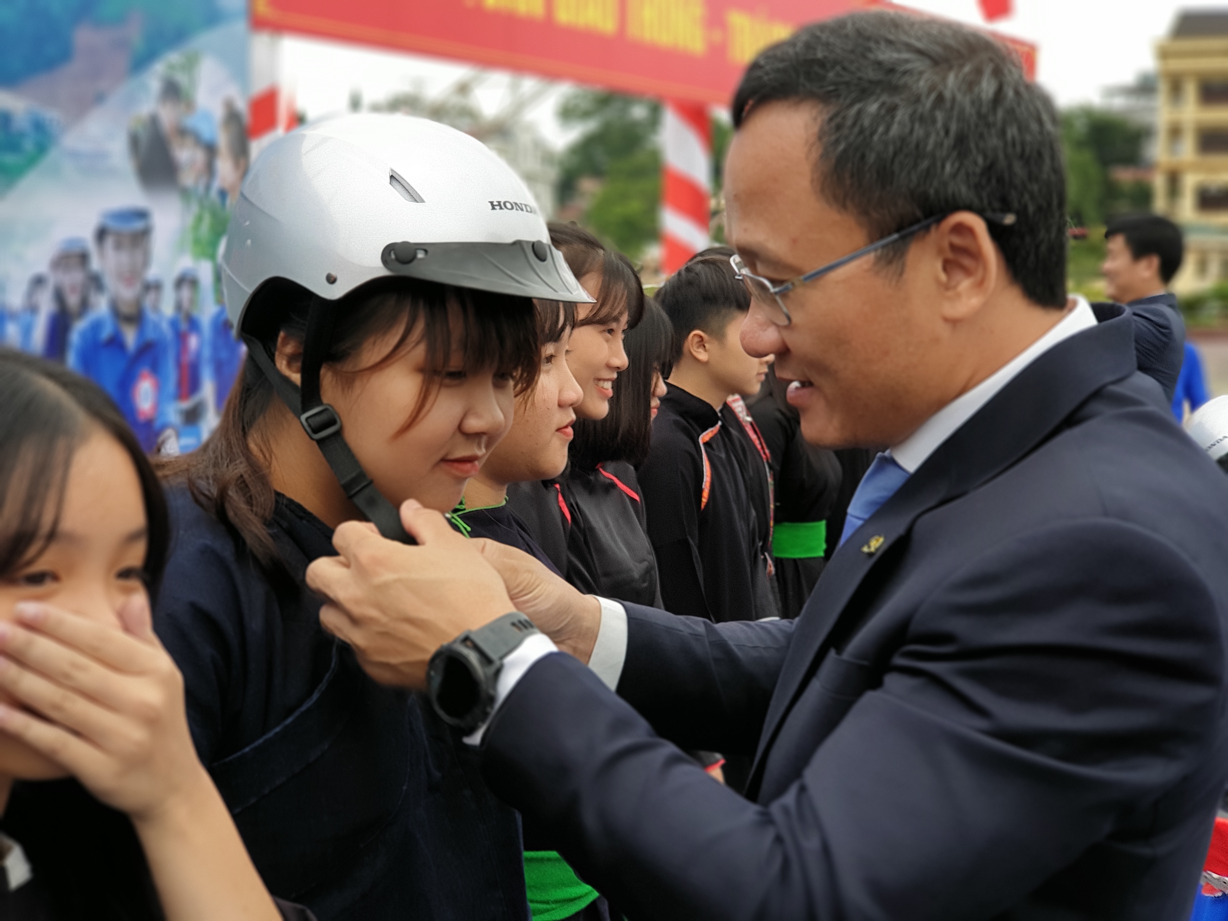 Ông Khuất Việt Hùng - Phó Chủ tịch chuyên trách UBATGTQG trao mũ cho đồng bào dân tộc Yên Bái