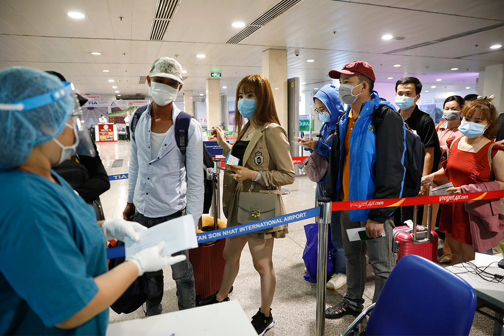 Nhân viên y tế đọc tên các hành khách chuẩn bị vào lấy mẫu xét nghiệm Covid-19 tại sân bay Tân Sơn Nhất, đầu tháng 5. Ảnh: Vnexpress