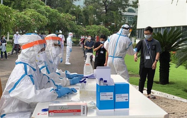 Các y bác sỹ Trung tâm kiểm soát bệnh tật Tp Hồ Chí Minh và Quận 7 thực hiện xét nghiệm sàng lọc COVID-19 ngẫu nhiên cho công nhân ở Khu chế xuất Tân Thuận. (Ảnh: Thanh Vũ/TTXVN)