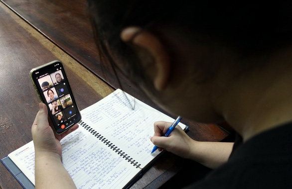 Một em học sinh học online tại nhà bằng điện thoại - Ảnh Tuổi trẻ