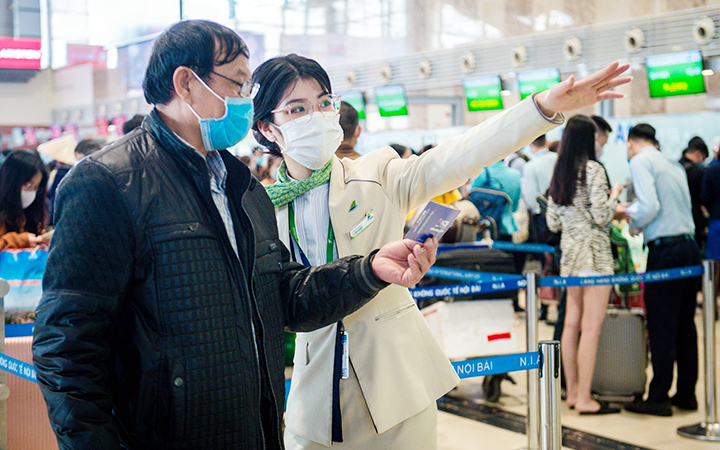 Nhân viên Hãng hàng không Bamboo Airways hướng dẫn hành khách tại cảng hàng không Nội Bài.