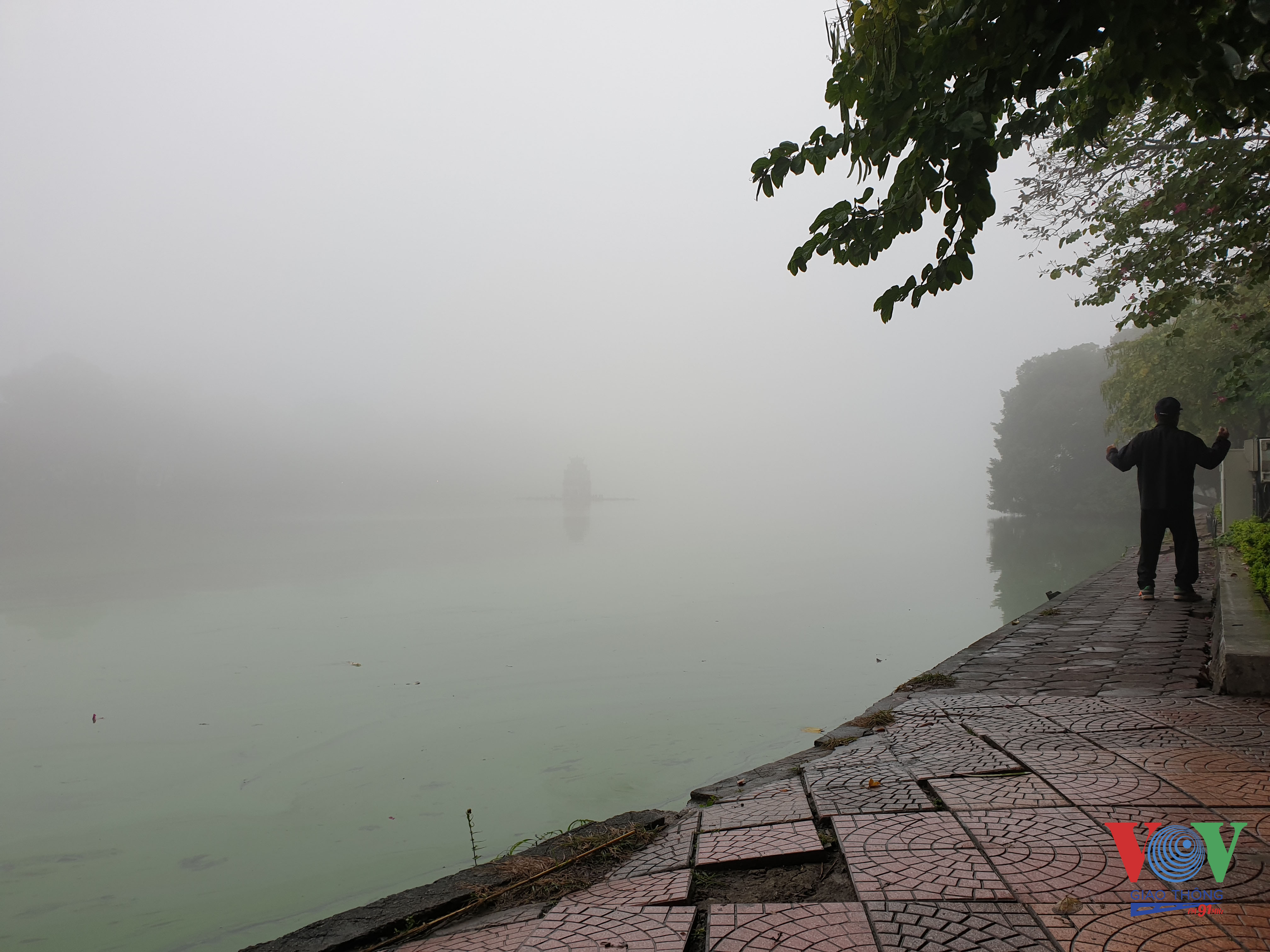 6 Những người đi tập thể dục quanh bờ hồ Hoàn Kiếm không thể nhìn rõ tháp rùa giữa hồ.