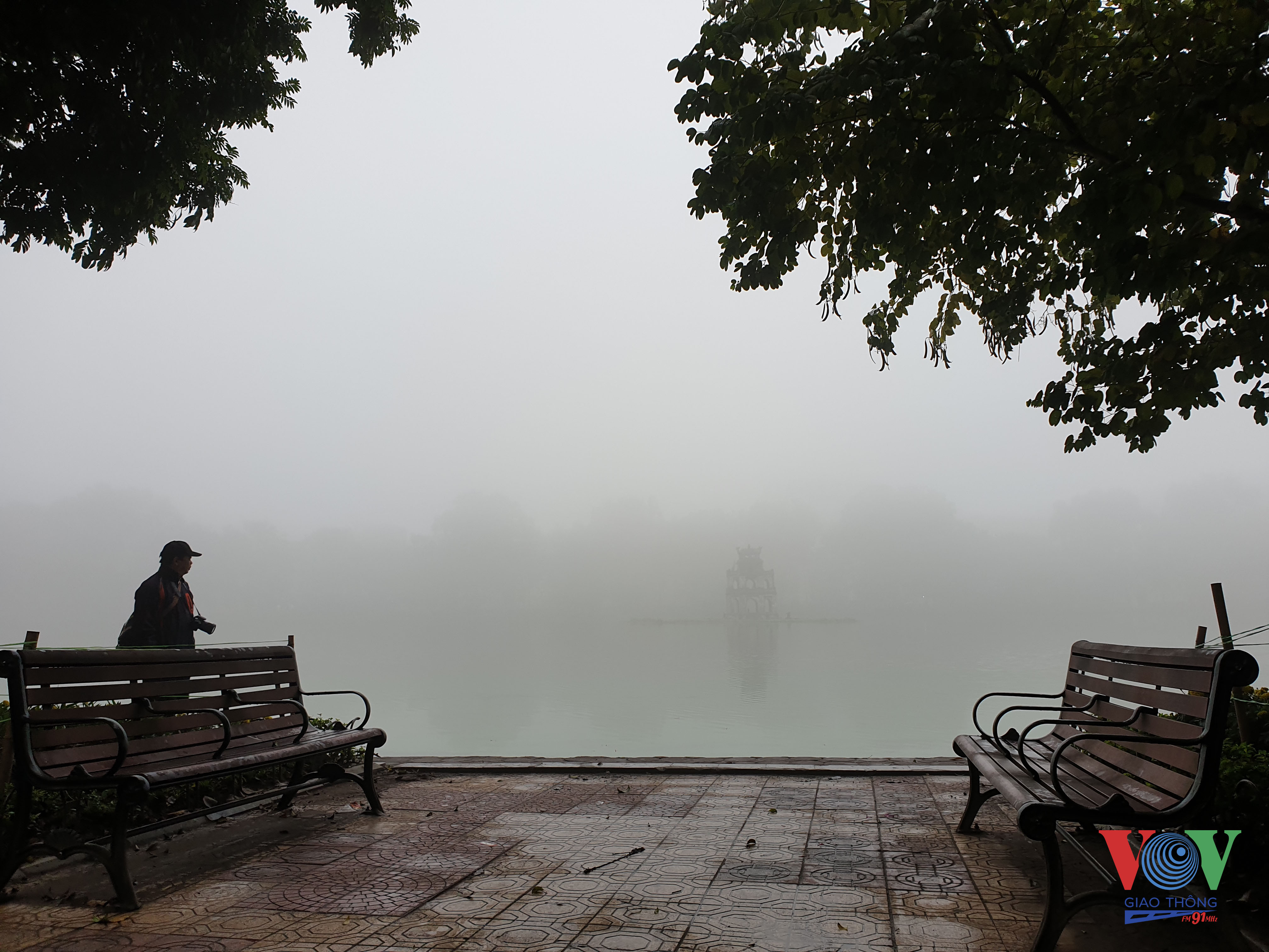 Những người đi tập thể dục quanh bờ hồ Hoàn Kiếm không thể nhìn rõ tháp rùa giữa hồ.